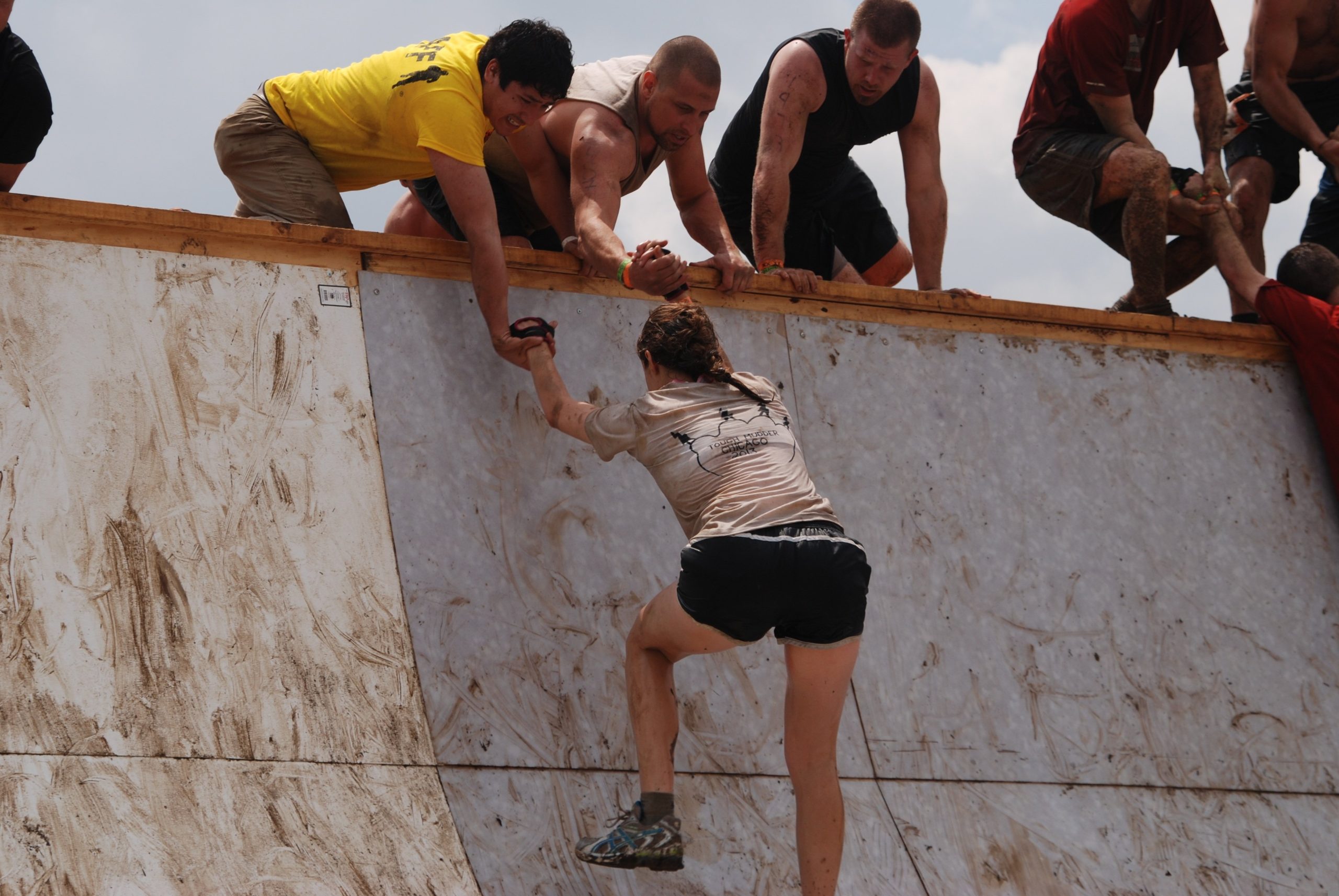 Picture of a team helping a person over a wall